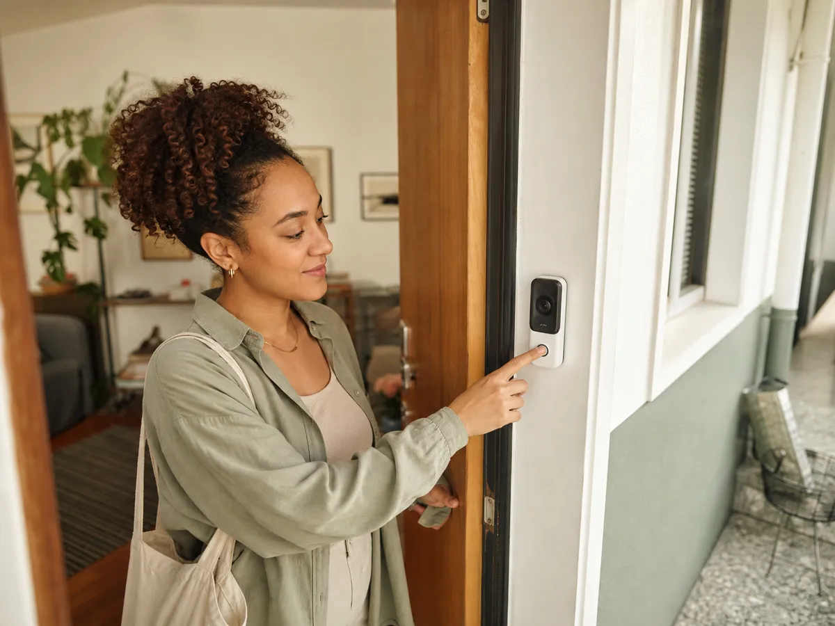 A renter checking a removable video doorbell mounted beside an apartment door